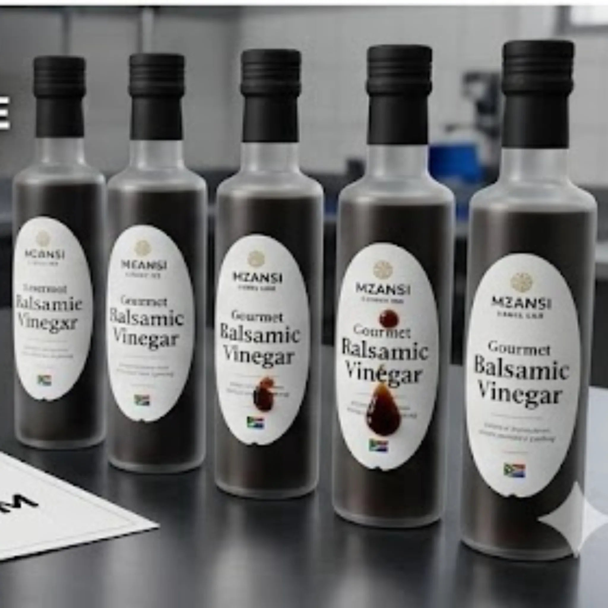 Five bottles of MZANISI Gourmet Balsamic Vinegar on a reflective surface with a blurred background. Compliance-Ready Food Labels: Nutrition & Ingredients